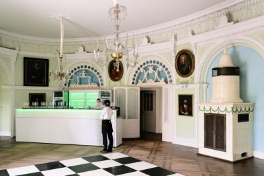 Thekenaufbau Empfangsbereich mit historischem Dekor und einem Mitarbeiter an der Theke.