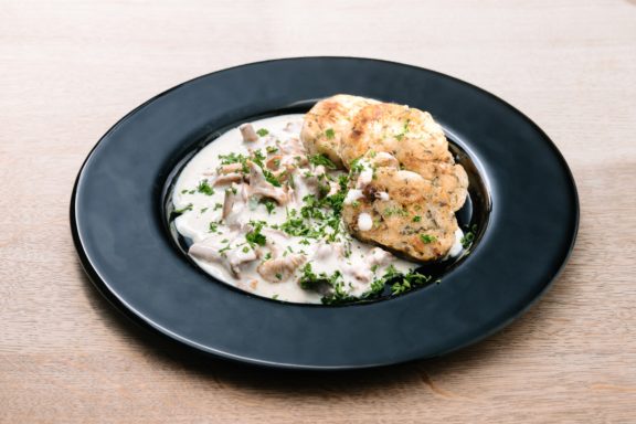 Cremiger Pilzrisotto mit knusprigen Kartoffelrösti und frischen Kräutern garniert.