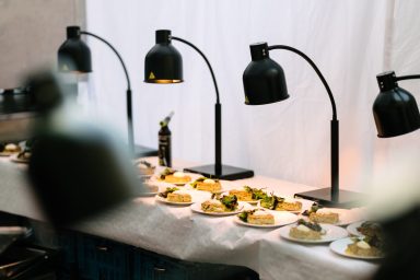 Outdoorküche 2 Ein Tisch mit beleuchteten Gerichten und Olivenölflasche im Hintergrund.