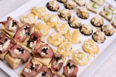 Canapés Ein Tablett mit verschiedenen Canapés, darunter Schinken, Käse und cremige Beläge.